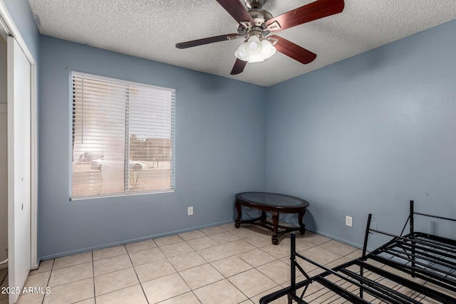 617 E Calle Adobe Ln, Goodyear, AZ 85338 - unfurnished bedroom featuring a textured ceiling, a closet, a ceiling fan, and light tile patterned floors