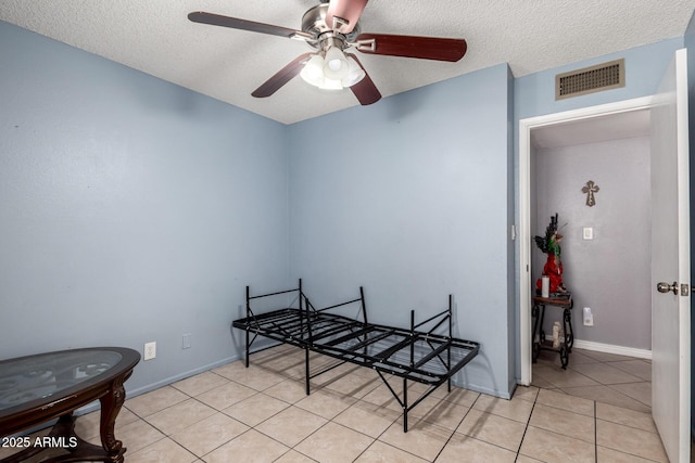617 E Calle Adobe Ln, Goodyear, AZ 85338 - bedroom featuring a textured ceiling, light tile patterned floors, and a ceiling fan