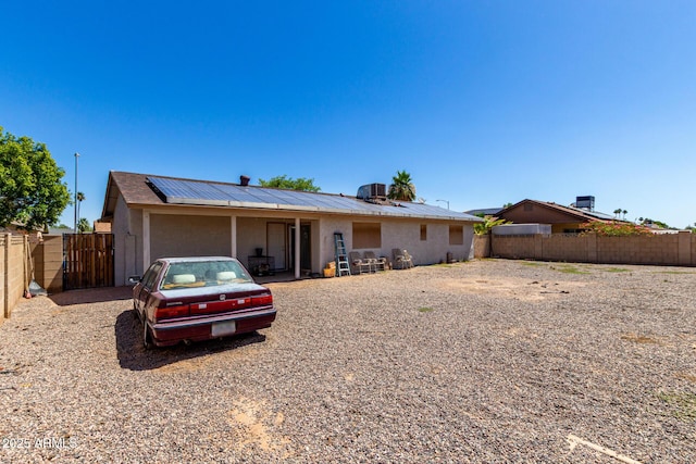617 E Calle Adobe Ln, Goodyear, AZ 85338 - view of front facade featuring solar panels, a gate, a fenced backyard, a metal roof, and stucco siding
