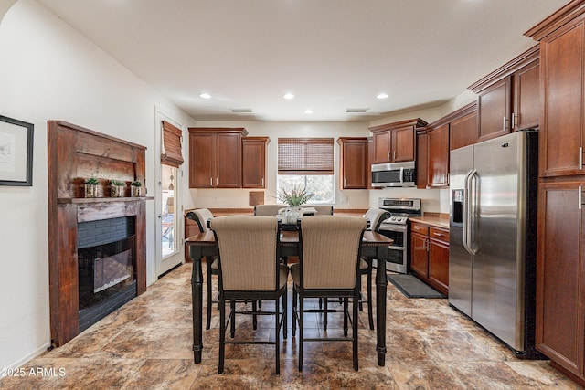 kitchen with visible vents, recessed lighting, appliances with stainless steel finishes, and a fireplace