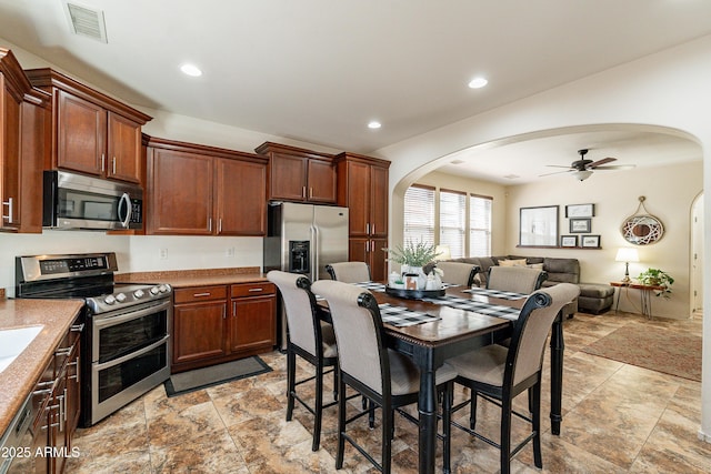 kitchen with visible vents, recessed lighting, arched walkways, stainless steel appliances, and open floor plan