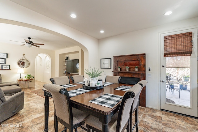 dining space featuring arched walkways, recessed lighting, and a ceiling fan