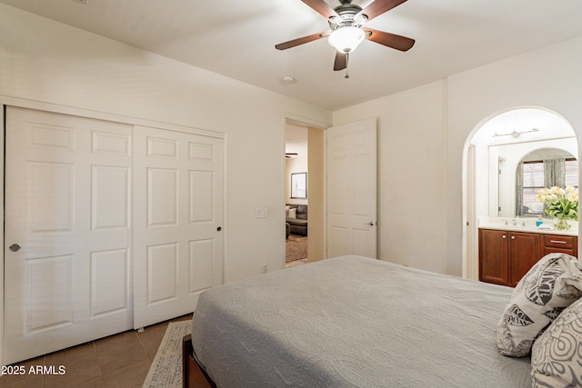 bedroom with ceiling fan, a sink, a closet, tile patterned floors, and connected bathroom