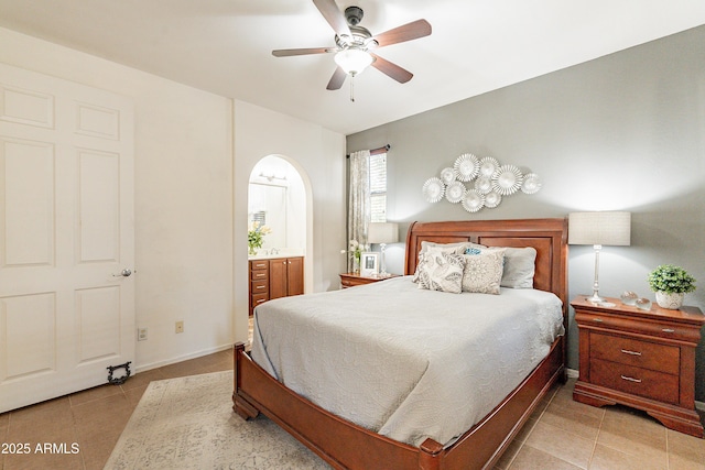 bedroom with light tile patterned floors, baseboards, ceiling fan, and ensuite bathroom