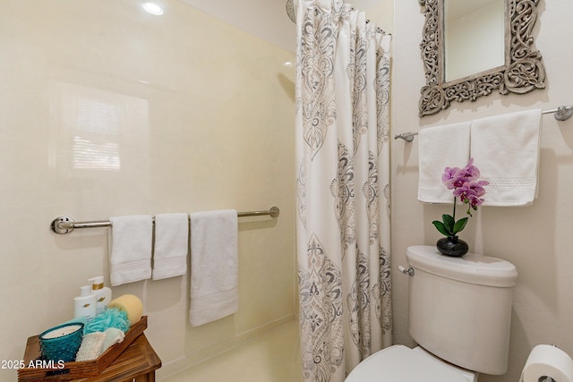 bathroom with a shower with shower curtain and toilet