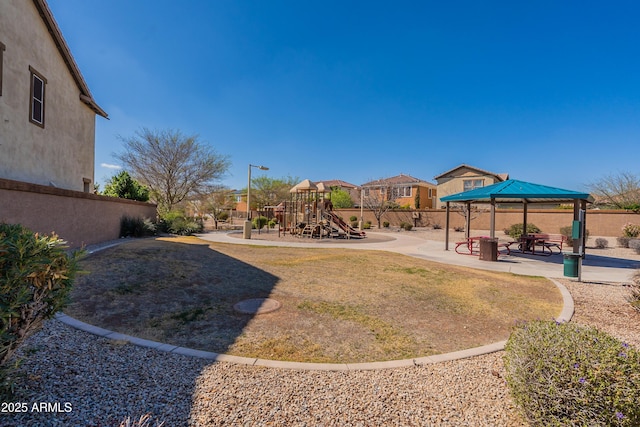 view of yard with a gazebo, fence, playground community, and a patio area