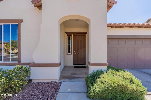 view of exterior entry featuring stucco siding and a tiled roof