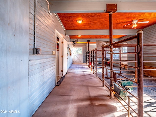 hallway with concrete floors and wooden walls