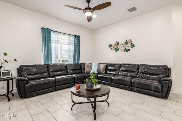 living room with visible vents, baseboards, and a ceiling fan