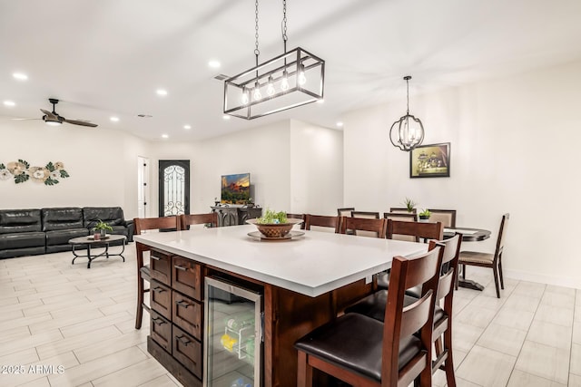 interior space featuring beverage cooler, open floor plan, a breakfast bar, light countertops, and recessed lighting