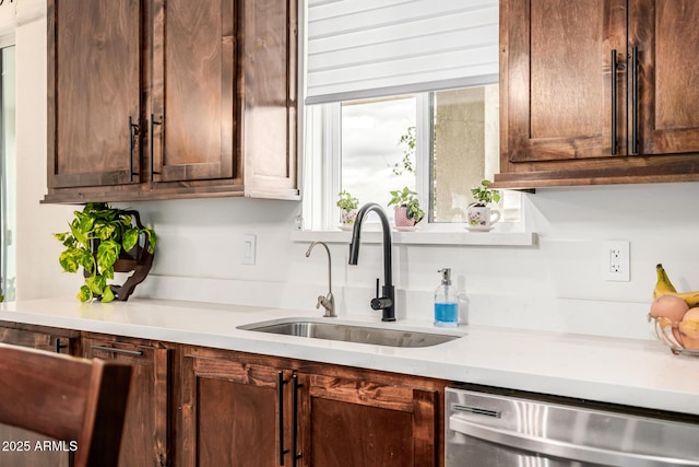 kitchen featuring a sink, dark brown cabinetry, dishwasher, and light countertops