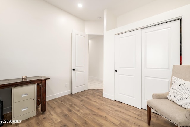 living area featuring light wood-style flooring, recessed lighting, and baseboards