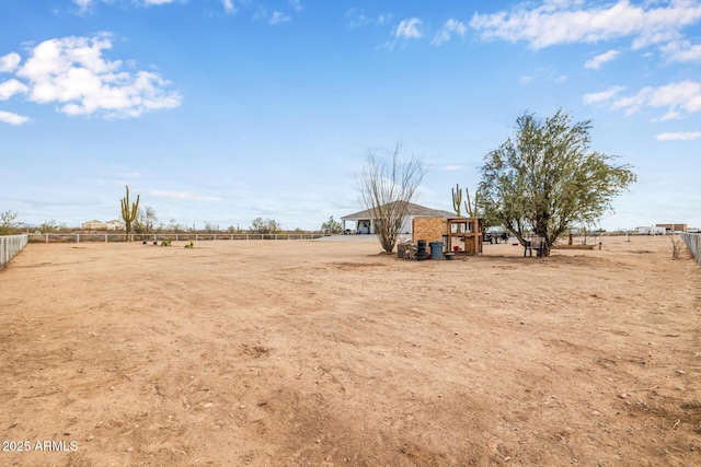 view of yard with a rural view and fence