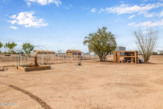 view of yard with a rural view, a vegetable garden, and fence