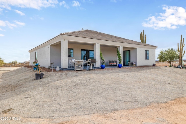 back of property featuring stucco siding