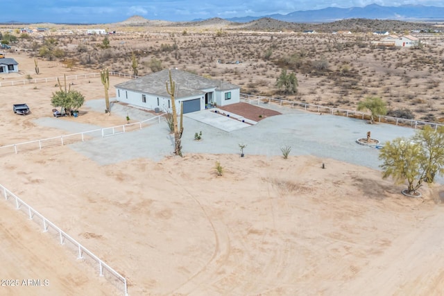 drone / aerial view featuring a mountain view, a rural view, and a desert view