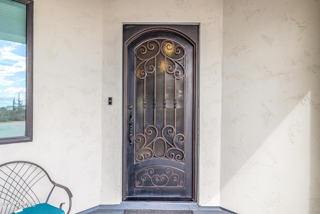 view of exterior entry featuring stucco siding