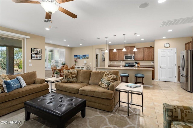 tiled living room featuring sink and ceiling fan