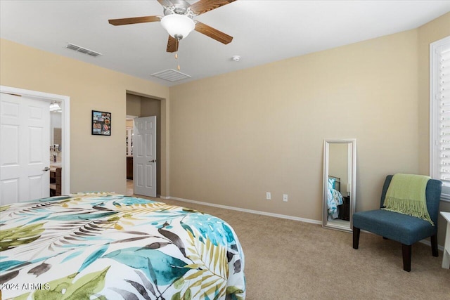 bedroom featuring ensuite bathroom, light carpet, and ceiling fan