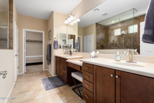 bathroom with tiled shower, tile patterned floors, and vanity