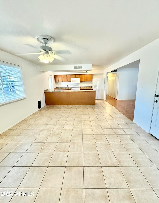 unfurnished living room featuring ceiling fan and light tile patterned floors