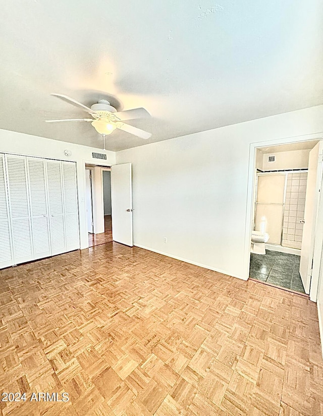 unfurnished bedroom featuring ceiling fan, light parquet flooring, and connected bathroom