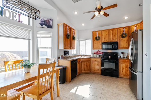 kitchen featuring sink, light stone counters, vaulted ceiling, light tile patterned floors, and black appliances