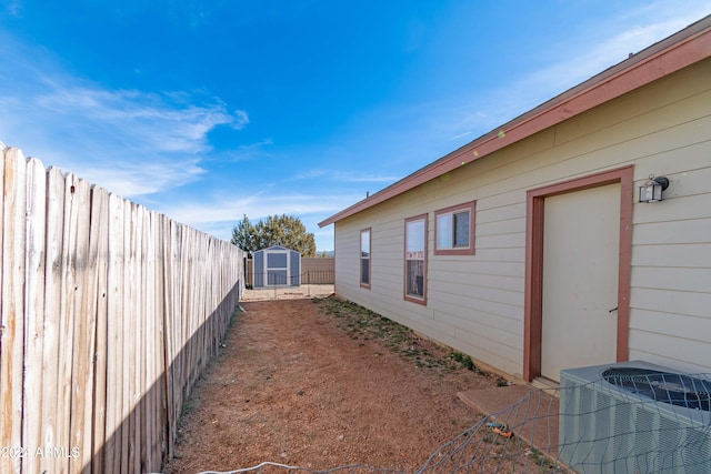 view of side of property with central AC and a shed