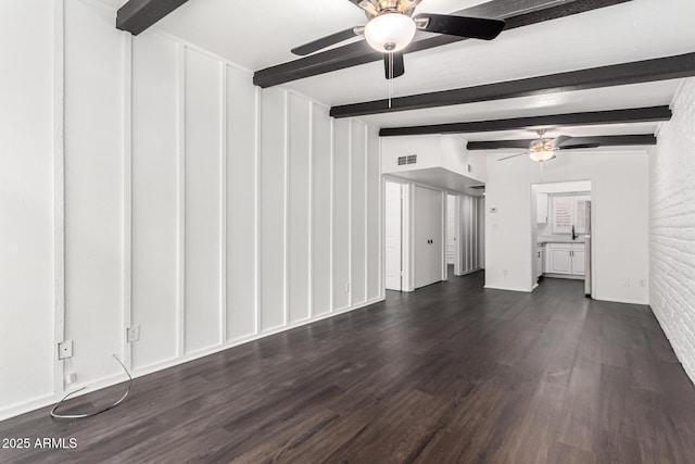 3046 N 32nd St Unit 328, Phoenix, AZ 85018 - unfurnished living room with beamed ceiling, visible vents, brick wall, ceiling fan, and dark wood-style flooring