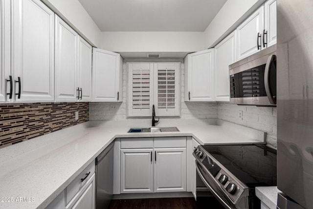 3046 N 32nd St Unit 328, Phoenix, AZ 85018 - kitchen featuring a sink, tasteful backsplash, dark wood-style floors, stainless steel appliances, and white cabinets