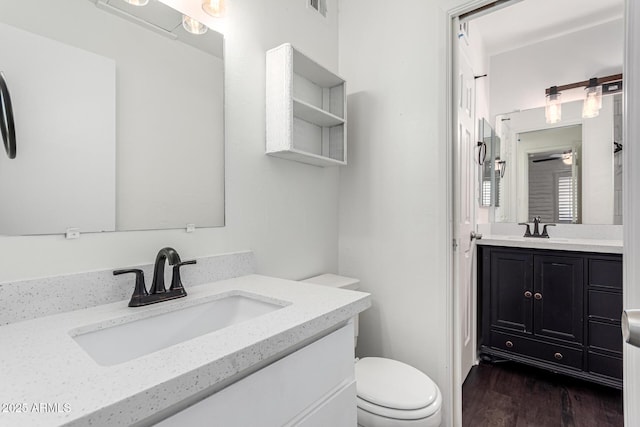 3046 N 32nd St Unit 328, Phoenix, AZ 85018 - bathroom with two vanities, toilet, wood finished floors, and a sink