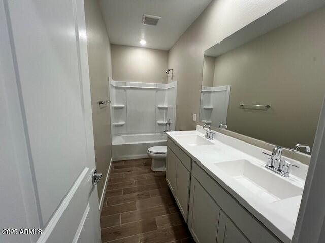 2945 S 232nd Dr, Buckeye, AZ 85326 - bathroom with toilet, double vanity, wood finish floors, and shower / tub combination