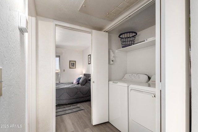 12123 W Bell Rd Unit 339, Surprise, AZ 85378 - laundry area featuring light wood-style floors, visible vents, separate washer and dryer, and laundry area