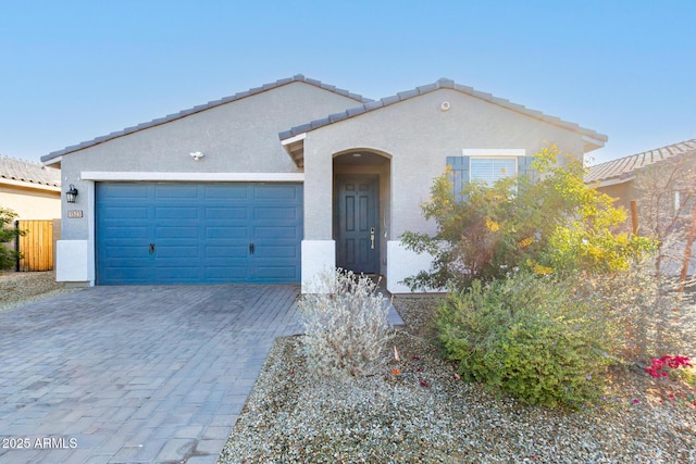 1523 S 223rd Dr, Buckeye, AZ 85326 - mediterranean / spanish-style house featuring an attached garage, stucco siding, decorative driveway, and a tile roof