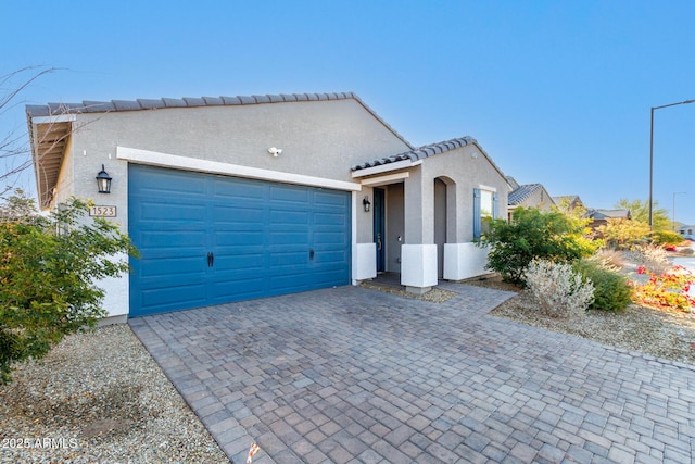1523 S 223rd Dr, Buckeye, AZ 85326 - mediterranean / spanish-style home featuring stucco siding, decorative driveway, and a garage