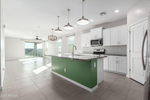 1523 S 223rd Dr, Buckeye, AZ 85326 - kitchen with appliances with stainless steel finishes, a sink, backsplash, dark stone countertops, and open floor plan