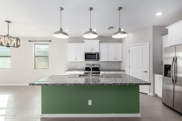 1523 S 223rd Dr, Buckeye, AZ 85326 - kitchen featuring appliances with stainless steel finishes, light tile patterned floors, backsplash, a sink, and white cabinets