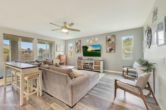 living room with ceiling fan, light hardwood / wood-style flooring, and a wealth of natural light