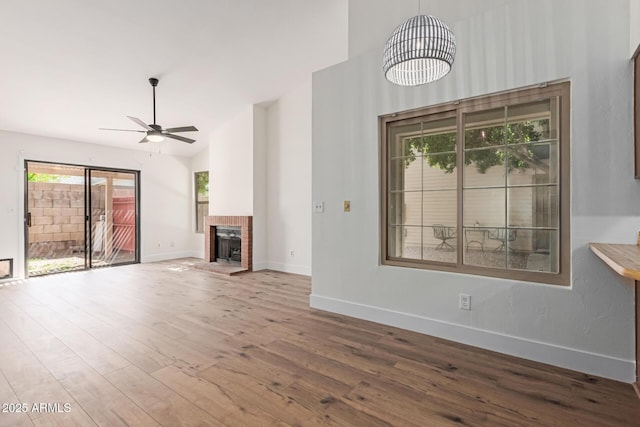 2455 E Broadway Rd Unit 39, Mesa, AZ 85204 - unfurnished living room featuring wood finished floors, ceiling fan, a towering ceiling, a fireplace, and baseboards