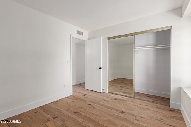 2455 E Broadway Rd Unit 39, Mesa, AZ 85204 - unfurnished bedroom featuring baseboards, wood finished floors, visible vents, and a closet