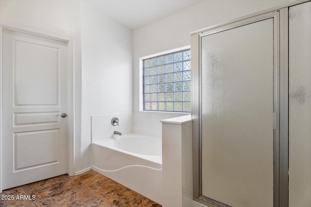 bathroom featuring shower with separate bathtub