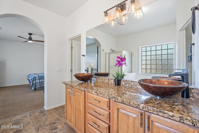 bathroom featuring vanity, a shower with shower door, and ceiling fan