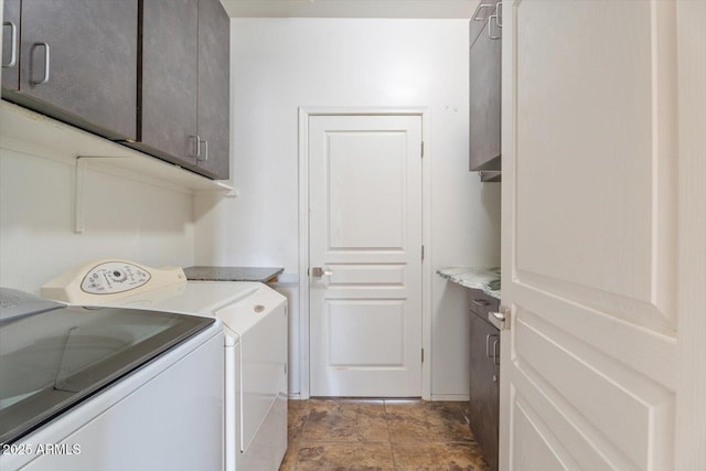 clothes washing area with cabinets and washing machine and clothes dryer