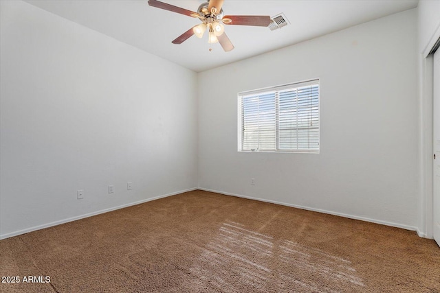 empty room featuring ceiling fan and carpet