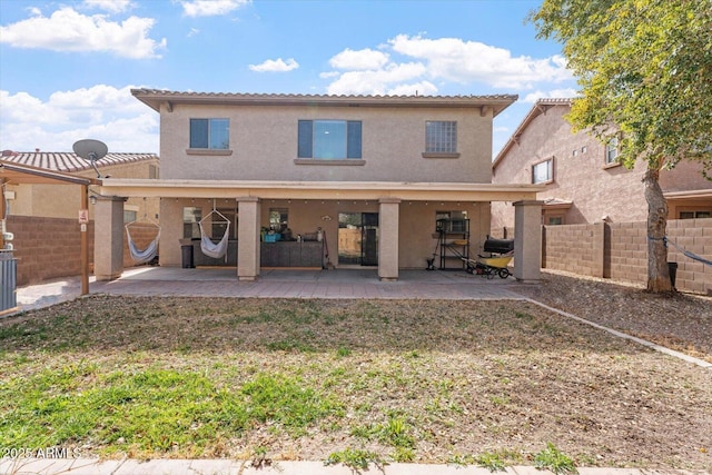 rear view of house with a patio and a lawn