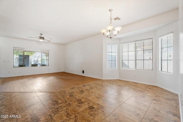 empty room featuring ceiling fan with notable chandelier and light tile patterned flooring