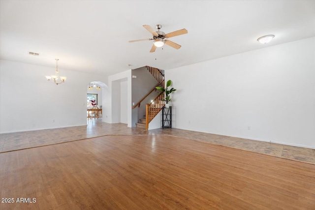 interior space featuring ceiling fan with notable chandelier and hardwood / wood-style floors