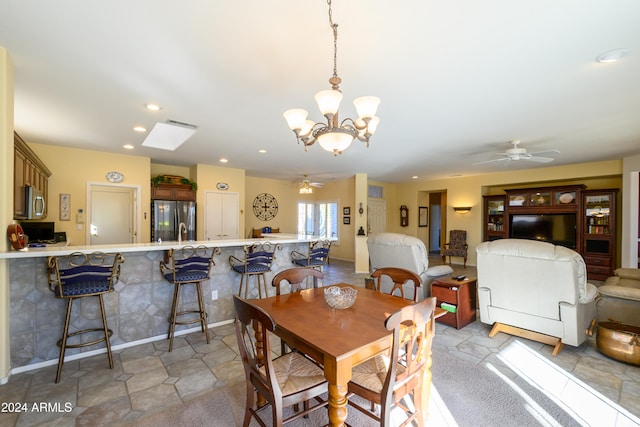 dining area featuring ceiling fan with notable chandelier