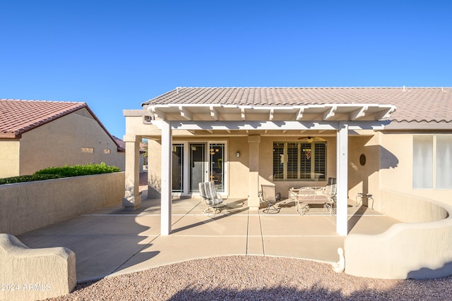 rear view of house featuring a pergola and a patio area