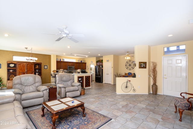 living room featuring ceiling fan with notable chandelier